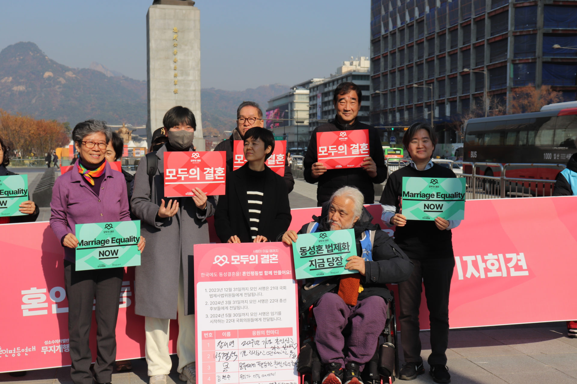 사진1. 기자회견에 참여한 발언자들. ‘모두의 결혼’, ‘Marriage Equality NOW’, ‘동성혼 법제화 지금 당장’이 적힌 피켓과 첫 서명을 기념하는 대형 서명판을 들고 있다.