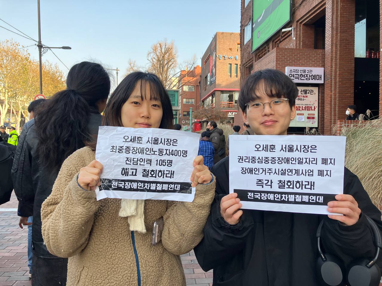 사진2. 서울인권영화제의 고운, 두부가 서울시의 차별 행정을 규탄하는 피켓을 각각 들고 있다.
