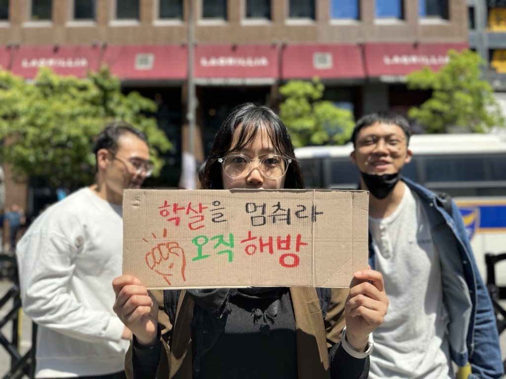 사진4. 서울인권영화제 상임활동가 고운이 종이상자에 '학살을 멈춰라 오직 해방'이라고 적은 피켓을 들고 있다.