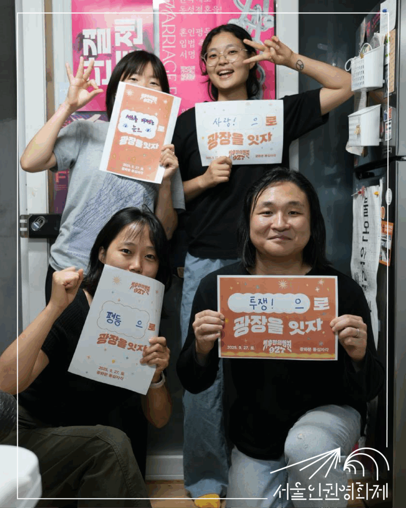 사진. 서울인권영화제 활동가 마주, 나기, 고운, 소하가 927 기후정의행진 피켓을 들고 포즈를 취한다. 피켓에는 각각 '서로를 바라보는 눈으로 광장을 잇자', '사랑으로 광장을 잇자', '평등으로 광장을 잇자', '투쟁으로 광장을 잇자'라고 적혀있다.