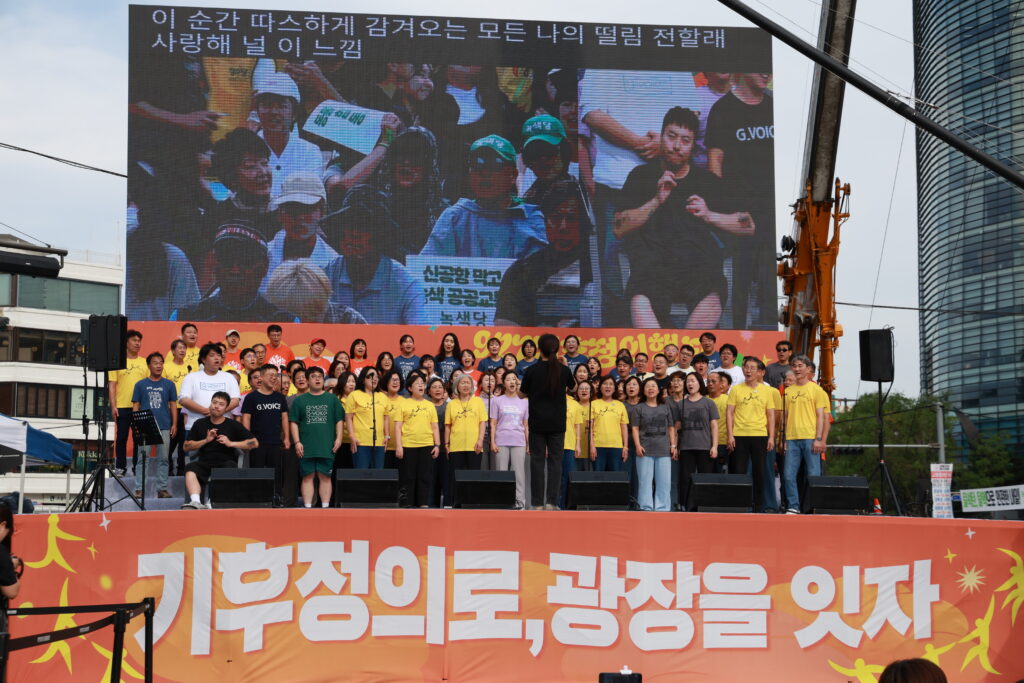 사진5. 무대를 가득 채운 927 기후정의합창단의 모습. 합창단 뒤 스크린에는 중계화면과 함께 수어통역, 문자통역이 진행되고 있다. (사진 출처: 927 기후정의행진 조직위)