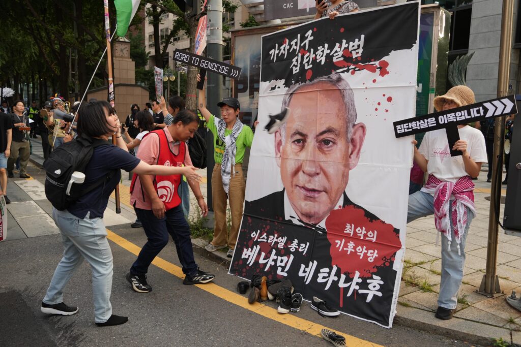 사진7. 5차 평화거점의 신발 던지기 퍼포먼스 모습. ‘가자지구 집단학살범 이스라엘 총리 최악의 기후악당 베냐민 네타냐후’라고 적힌 네타냐후의 사진이 커다랗게 인쇄되어 있다. 이를 향해 참가자가 신발을 던지고 있다. 네타냐후는 이번 927 기후정의행진 기후걸림돌 온라인 투표에서 1위를 차지하기도 했다.