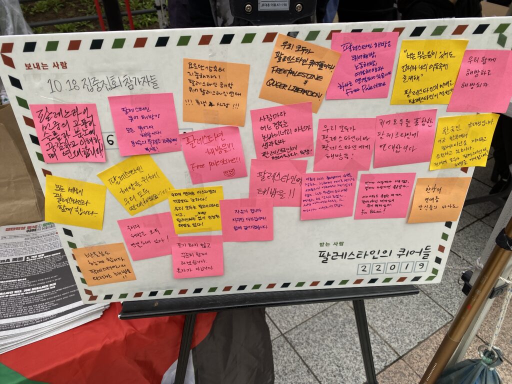 사진3. 엽서 모양 보드에 '팔레스타인 민중의 고통과 슬픔과 분노에 공감하고 이해하며 연대합니다', '반올림도 함께합니다. 팔레스타인의 완전한 해방을!', 등등 다양한 메시지들이 포스트잇으로 붙어 있다. 받는 사람에는 '팔레스타인의 퀴어들'이라고 적혀 있다.