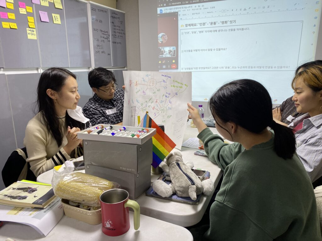 사진. 서울인권영화제 사무실. '인권', '운동', '영화' 각각에 연상되는 키워드를 적어 서로 연결한 종이를 들고 이음활동가들이 발표 중이다.