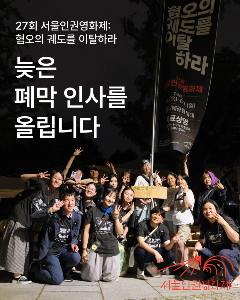 사진. 27회 서울인권영화제 현수막 아래, 활동가들이 손가락으로 3을 세는 포즈로 사진을 찍는다.