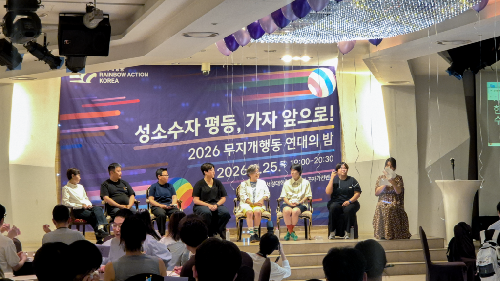 사진3. 토크쇼 무대 모습. 왼쪽부터 오른쪽으로 일란, 종걸, 야릉, 예림(수어통역), 서연, 소연, 진영(수어통역), 에디. 천장에 풍선들이 늘어졌다.