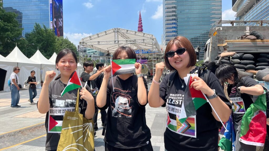 사진3. 기자회견에 참여한 서울인권영화제 활동가들이 작은 팔레스타인 국기를 들고 주먹을 든 포즈.