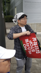 [사진] 쿠피예 무늬 반다나를 머리에 두르고 ‘NO 이스라엘 STOP 집단학살’ 피켓을 들고 있는 윤진. 촬영: 서인